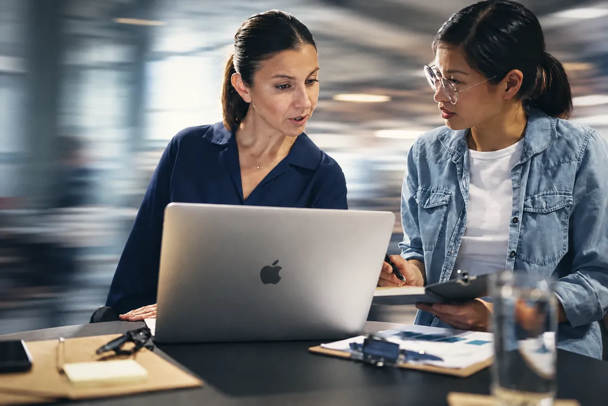 Two colleagues discussing something on a laptop